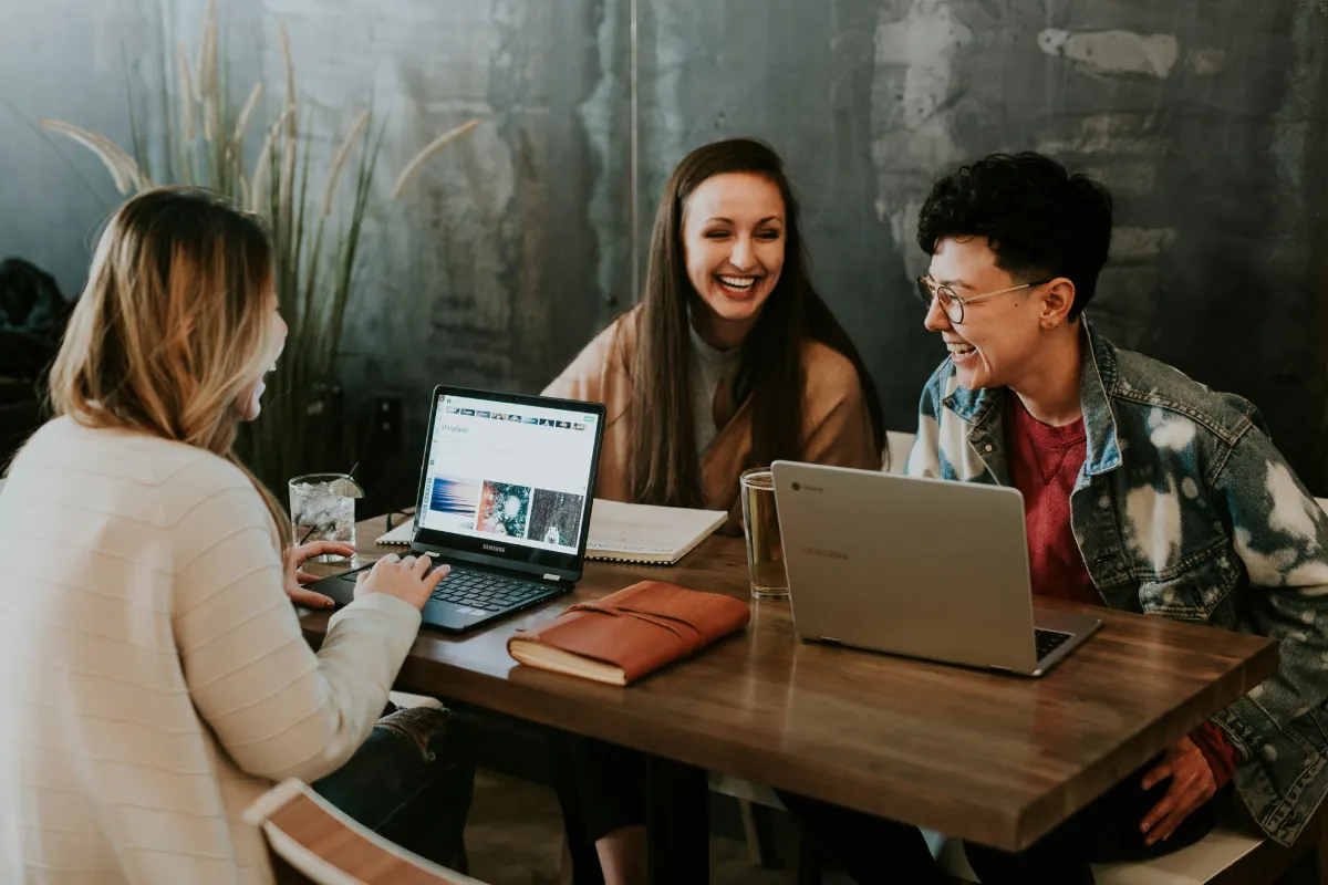 a team of people at the table are laughing, and seem happy